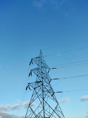 Photo of a secured pylon structure against a clear blue sky in Yopougon.