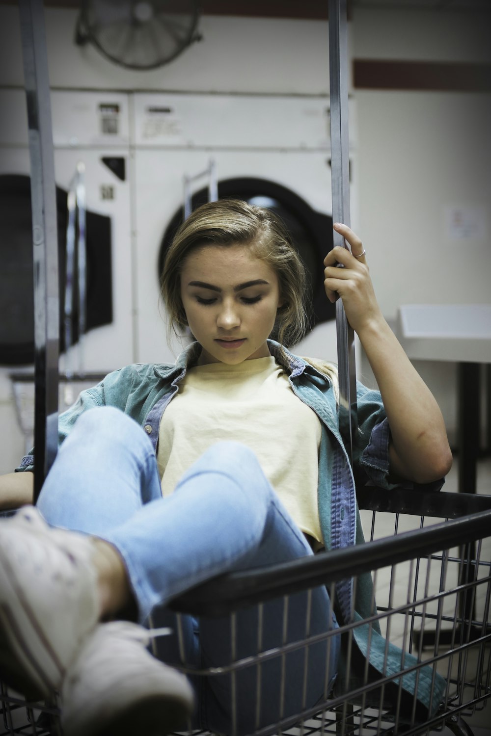 woman sitting on grocery cart