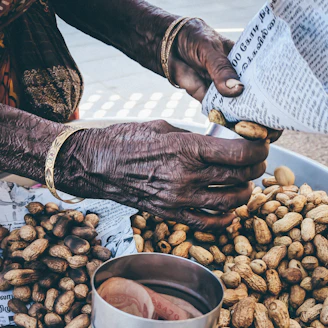 Golden peanut gajak pieces wrapped in traditional paper.