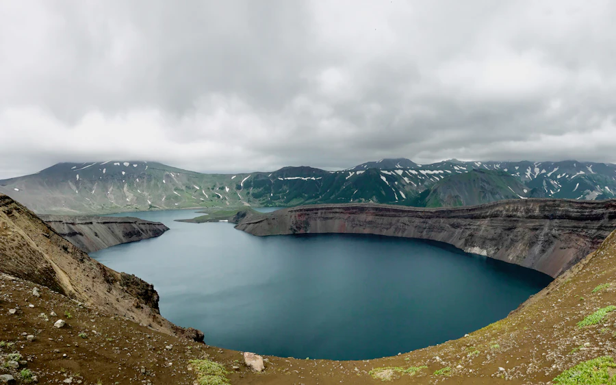 A crater lake framed by green highland walls