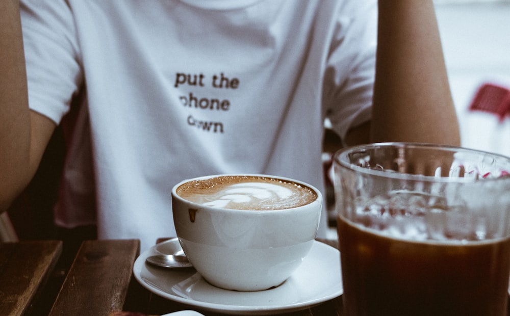 person sitting on chair in front of cappucino