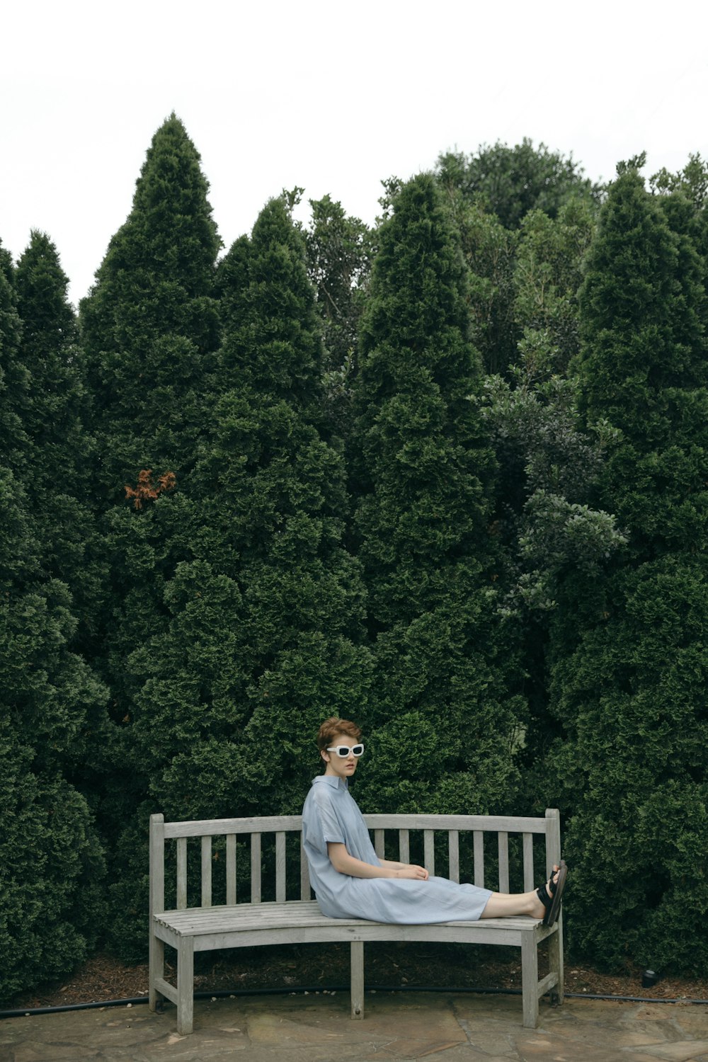 person in gray dress sitting on gray bench