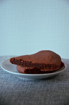Close-up of a rich, fudgy no egg brownie on a rustic wooden plate.