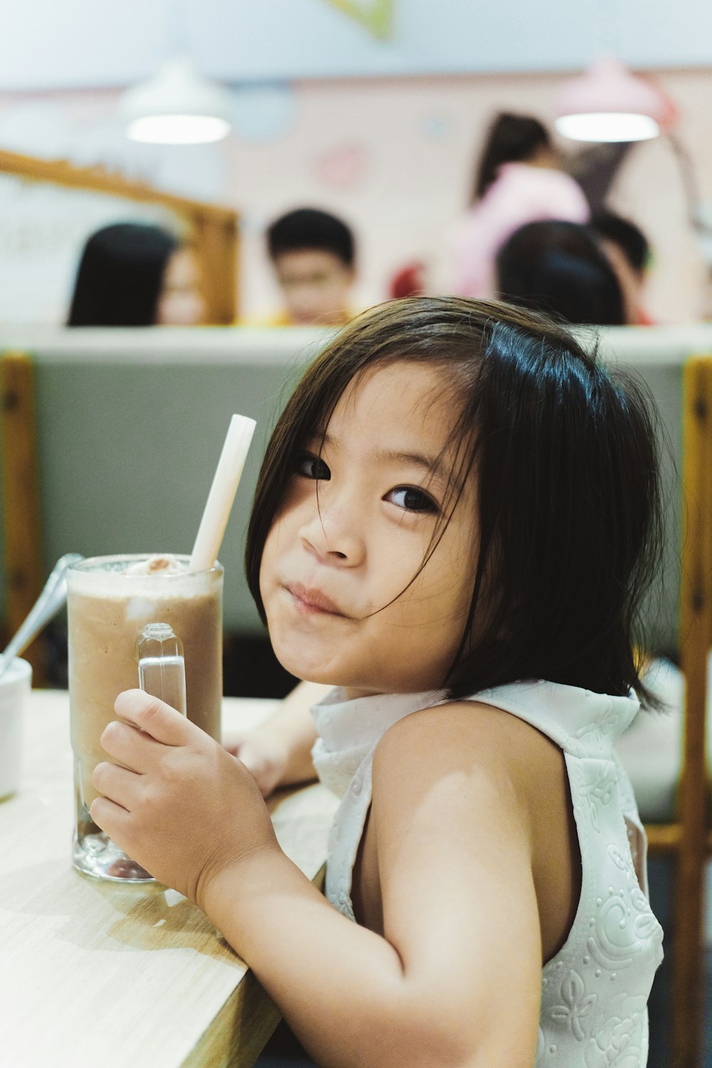 girl holding cup filled with black liquid