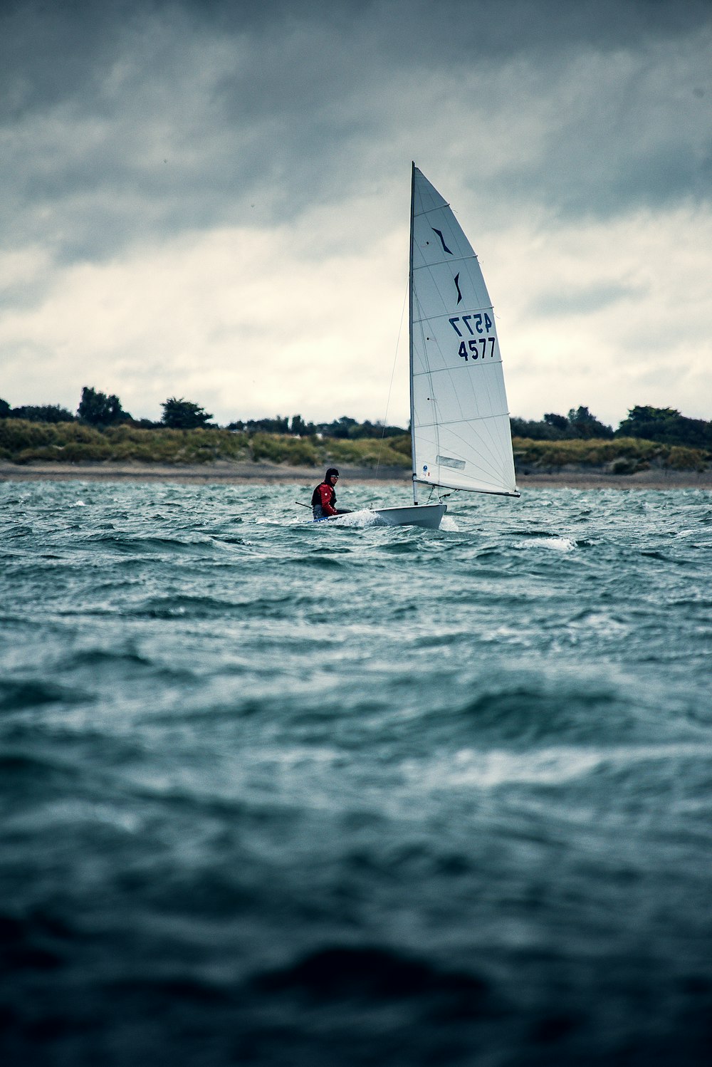 man riding sailboat during day