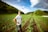 A happy customer standing in a lush farmland.