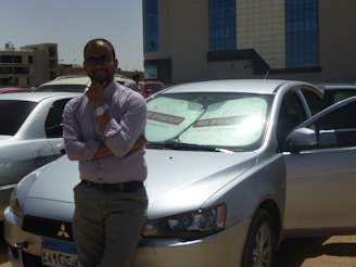 A friendly Shaw Auto Glass technician assisting a customer beside a parked car.