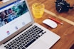 A professional marketer analyzing digital ad performance on a laptop in a modern office.