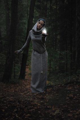 A young man standing at the edge of a mystical forest, gazing toward a glowing ancient key floating in the air.