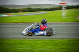 Savannah Maddox leaning into a sharp turn on her kart, dust flying behind her.