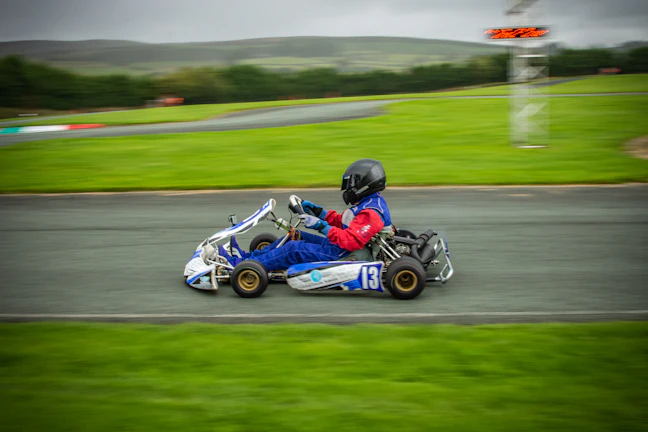 Savannah Maddox leaning into a sharp turn on her kart, dust flying behind her.