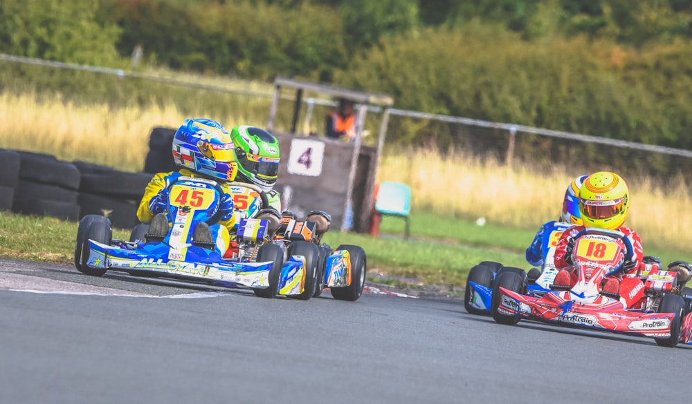 four go kart racers on road during daytime