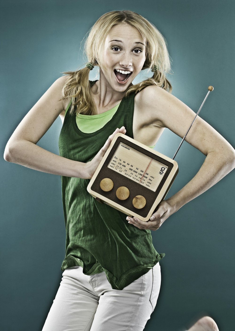 smiling woman holding brown transistor radio