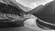 A winding river cutting through rugged mountain terrain, captured from above.