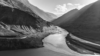 A winding river cutting through rugged mountain terrain, captured from above.