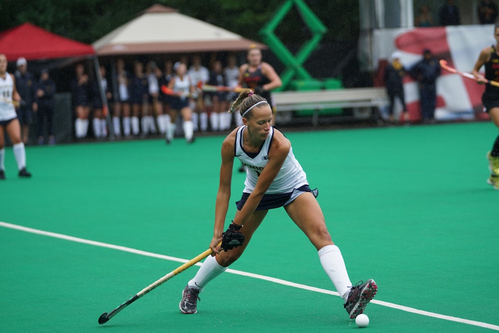 woman holding hockey stick on field