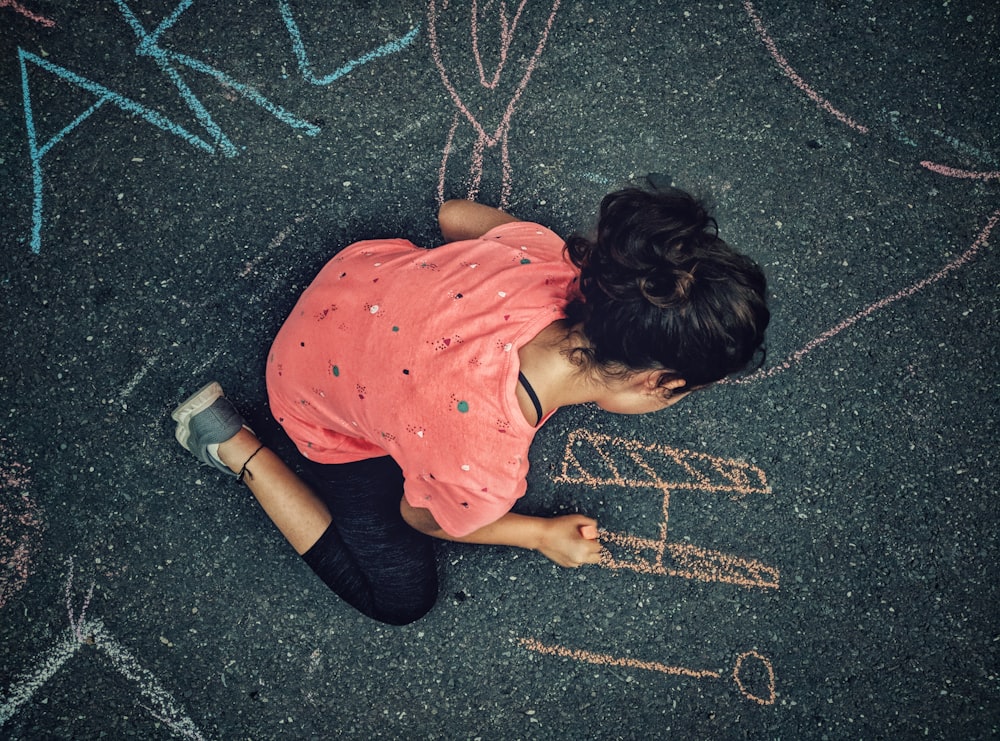 woman painting on gray concrete floor during daytime