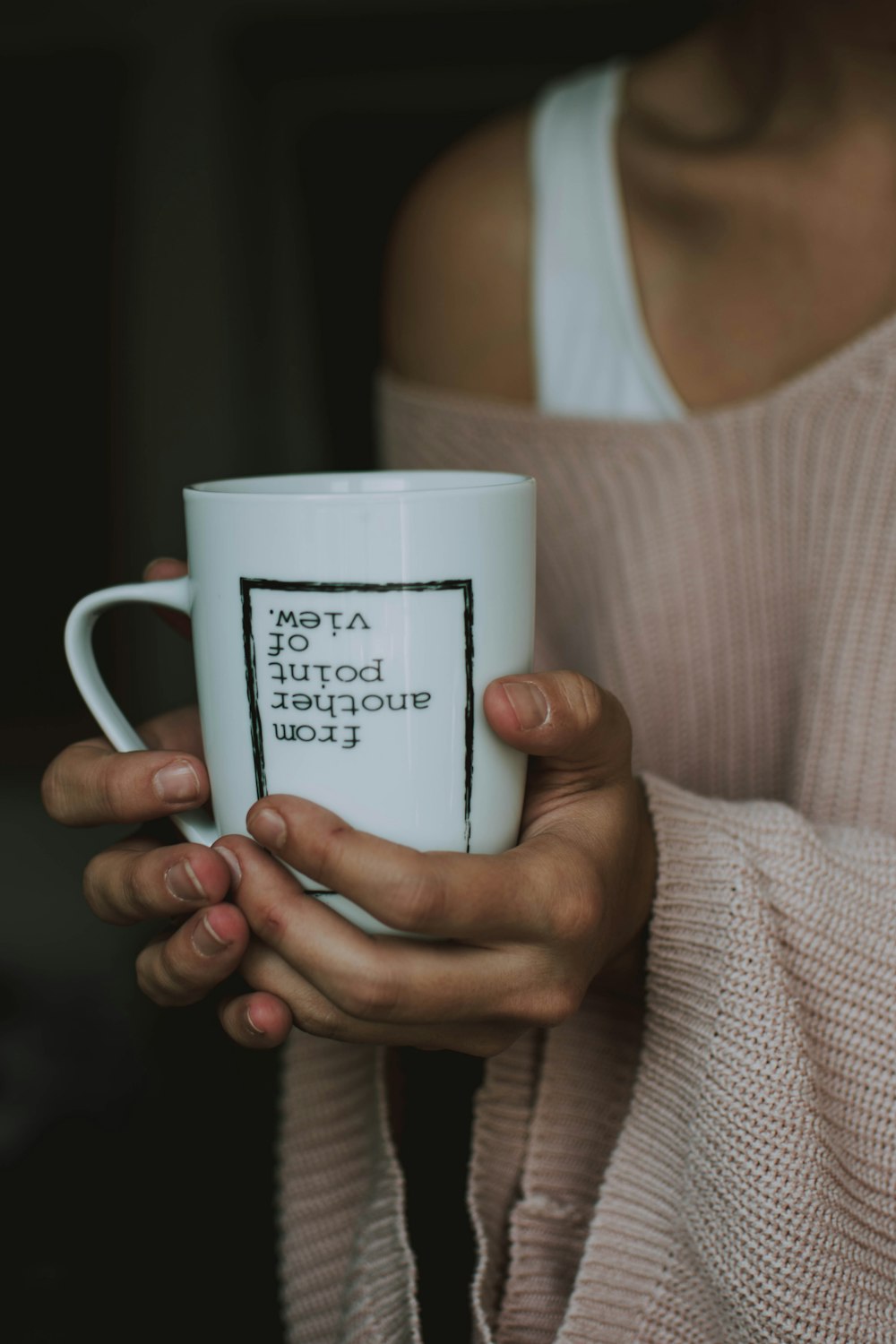 Mujer sosteniendo taza de cerámica blanca