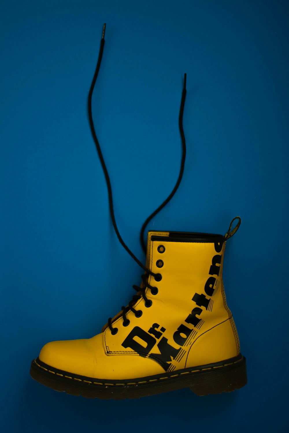 unpaired yellow and brown Dr. Martens leather work boot