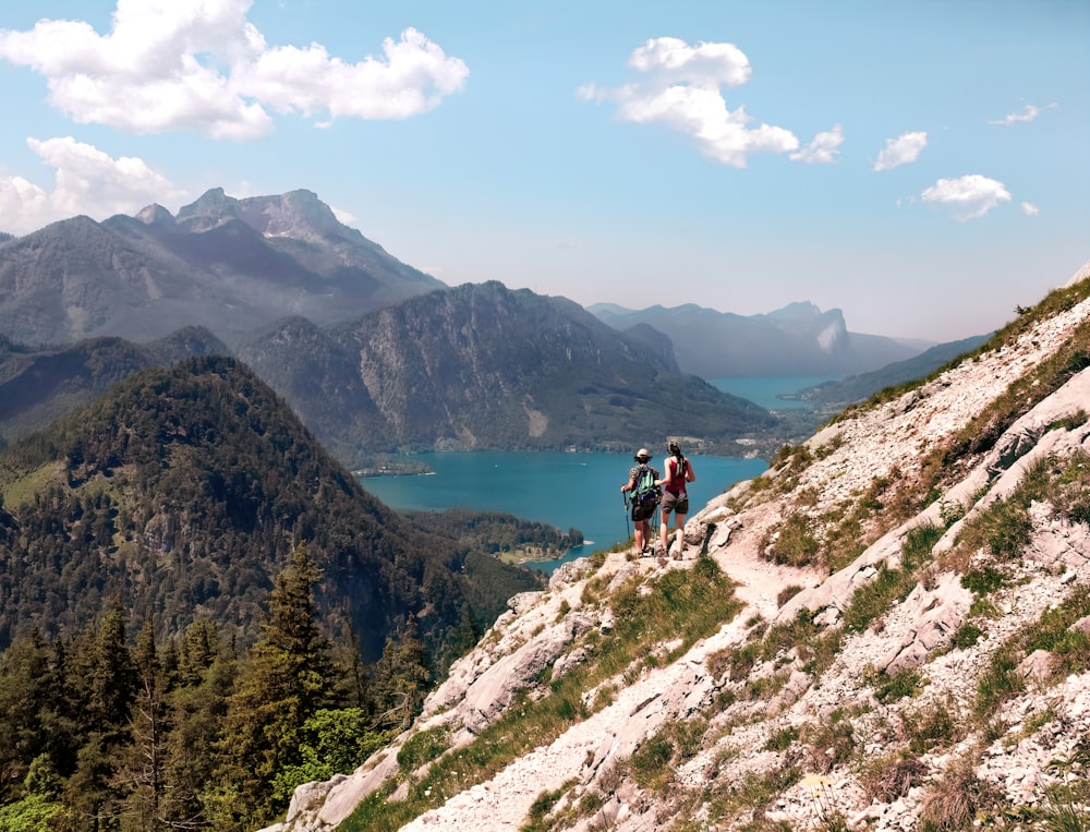 two person standing on mountain cliff