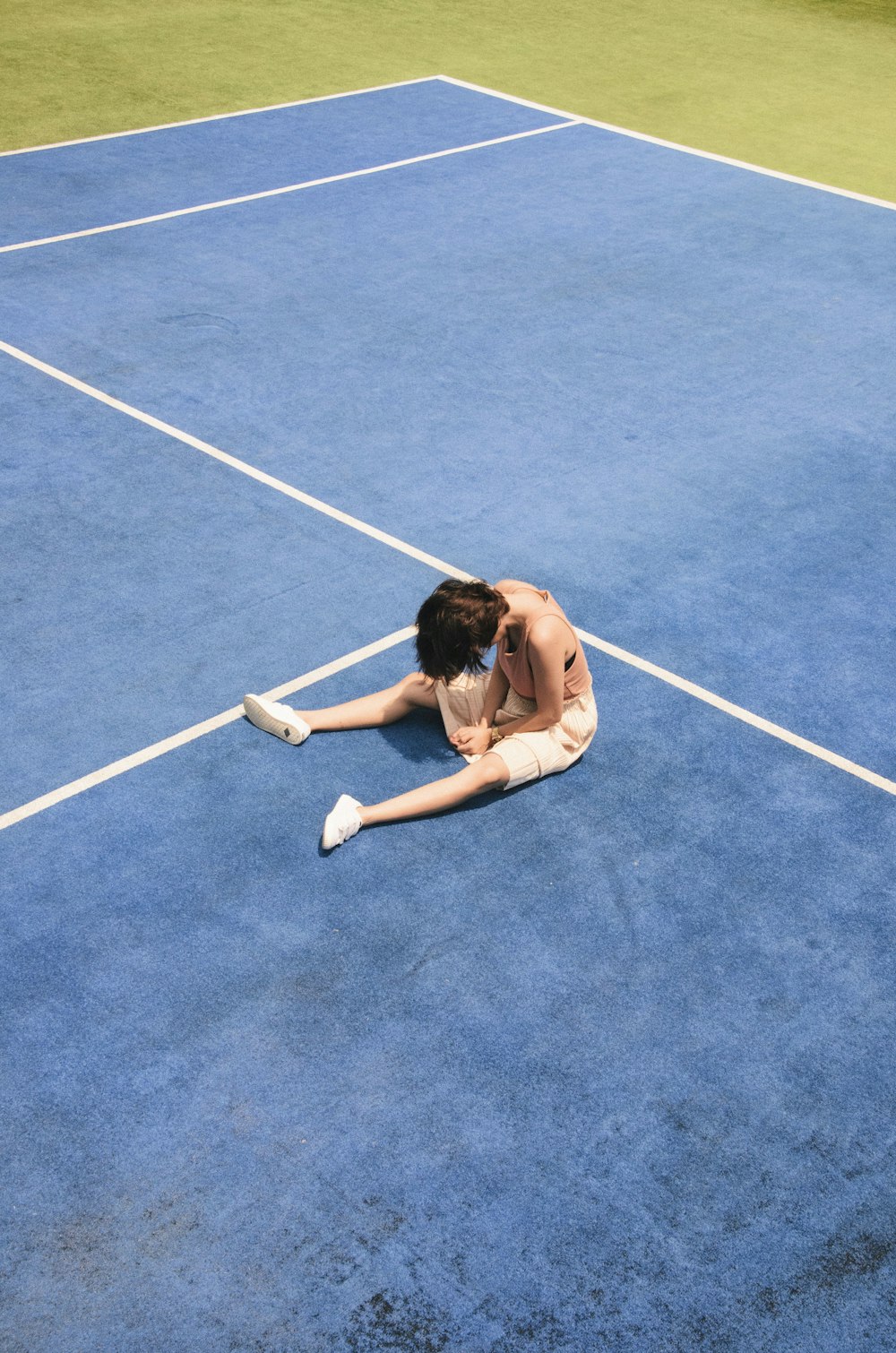 woman sitting on tennis court during daytime