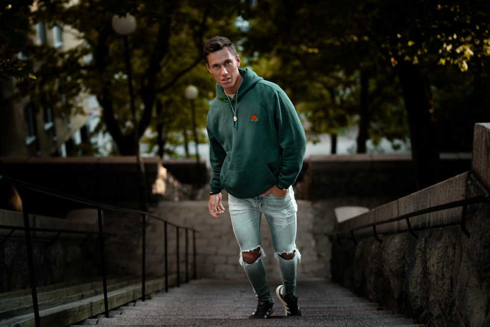 man in green hoodie on stair