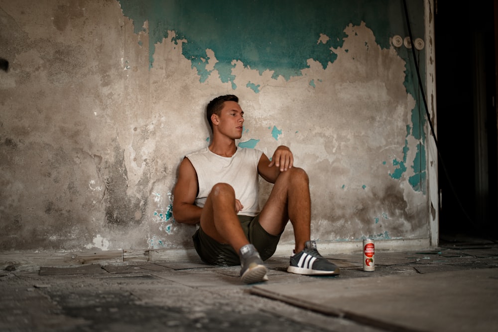 man sitting beside wall