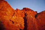 Red rock formations glowing in the Valley of Fire under a clear blue sky.