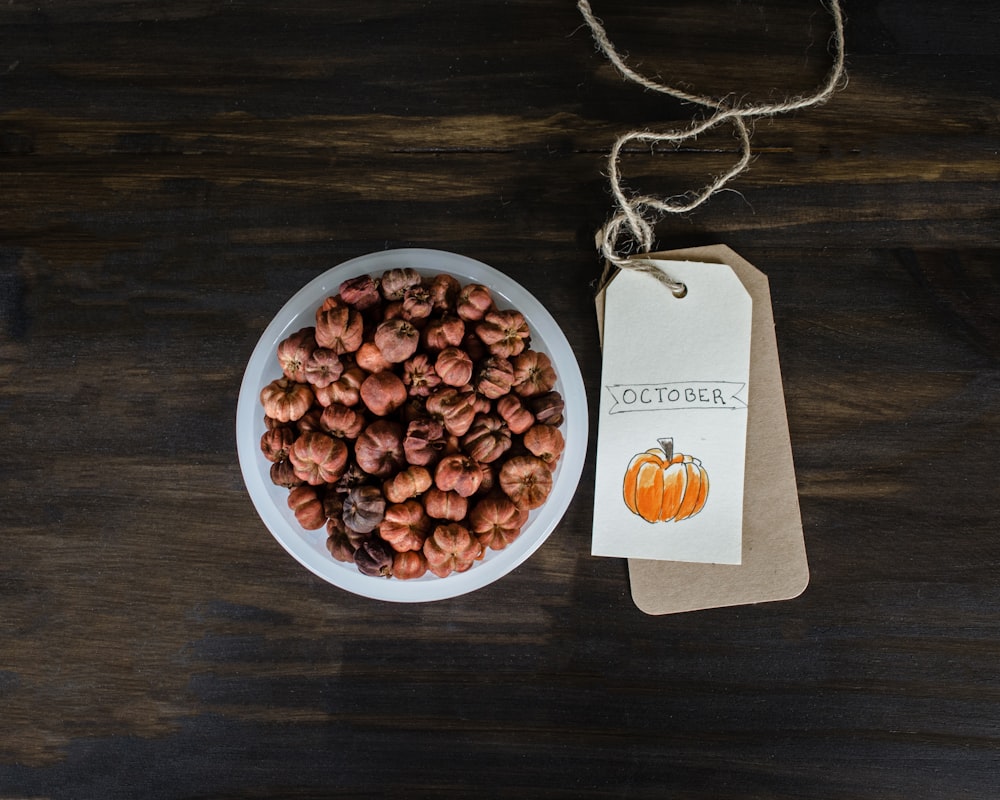 brown nuts on white bowl near tag