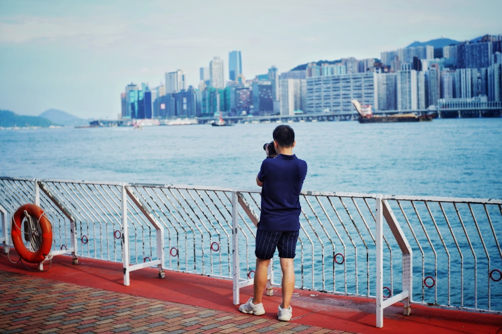 man taking photo of city buildings