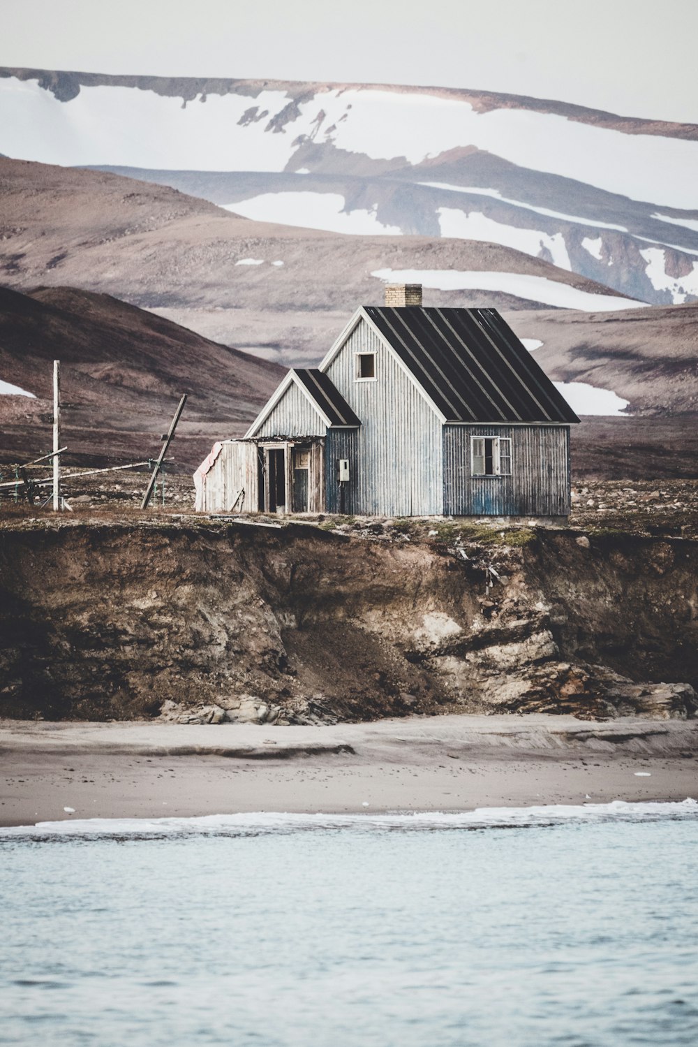 gray wooden house on land near body of water
