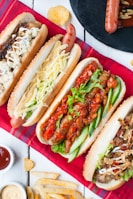 A colorful plate of crispy hot dogs topped with fresh veggies and sauces, styled on a modern ceramic dish.