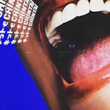 A close-up image of an open mouth with visible teeth and a prominent tongue. The lips are colored with a deep red shade, contrasting with the white teeth. The background features a blue color with text, including the word 'CHINTAI' repeated multiple times in white, along with other symbols.