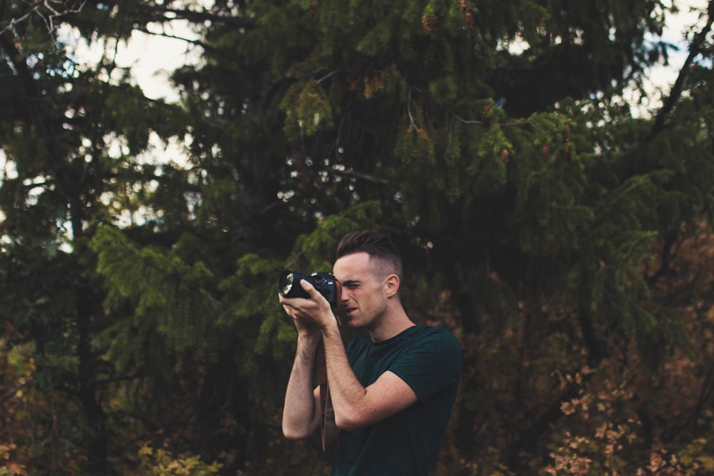 man capturing photo using DSLR camera
