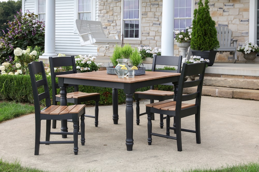 Mesa de comedor cuadrada de madera marrón y negra rodeada de sillas de comedor