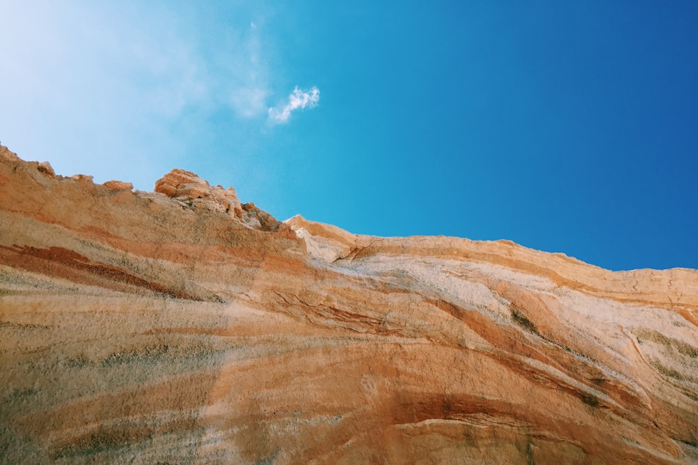 wide angle photo of brown mountain under blue sky