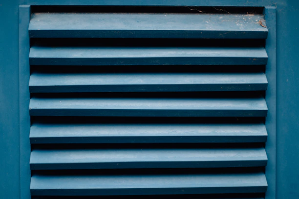 Close-up of a homeowner inspecting a dryer vent for blockages.