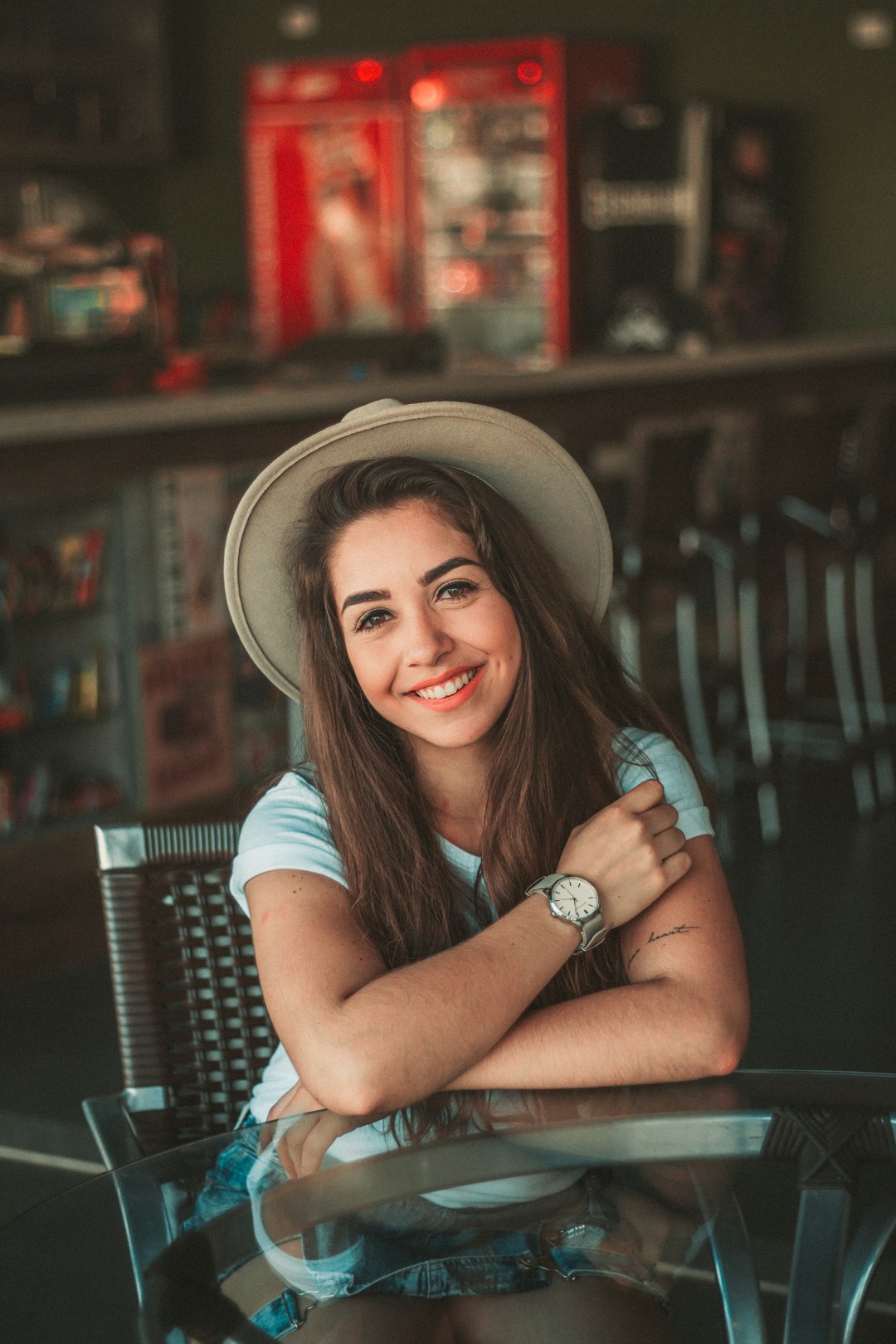woman sitting while smiling and wearing hat