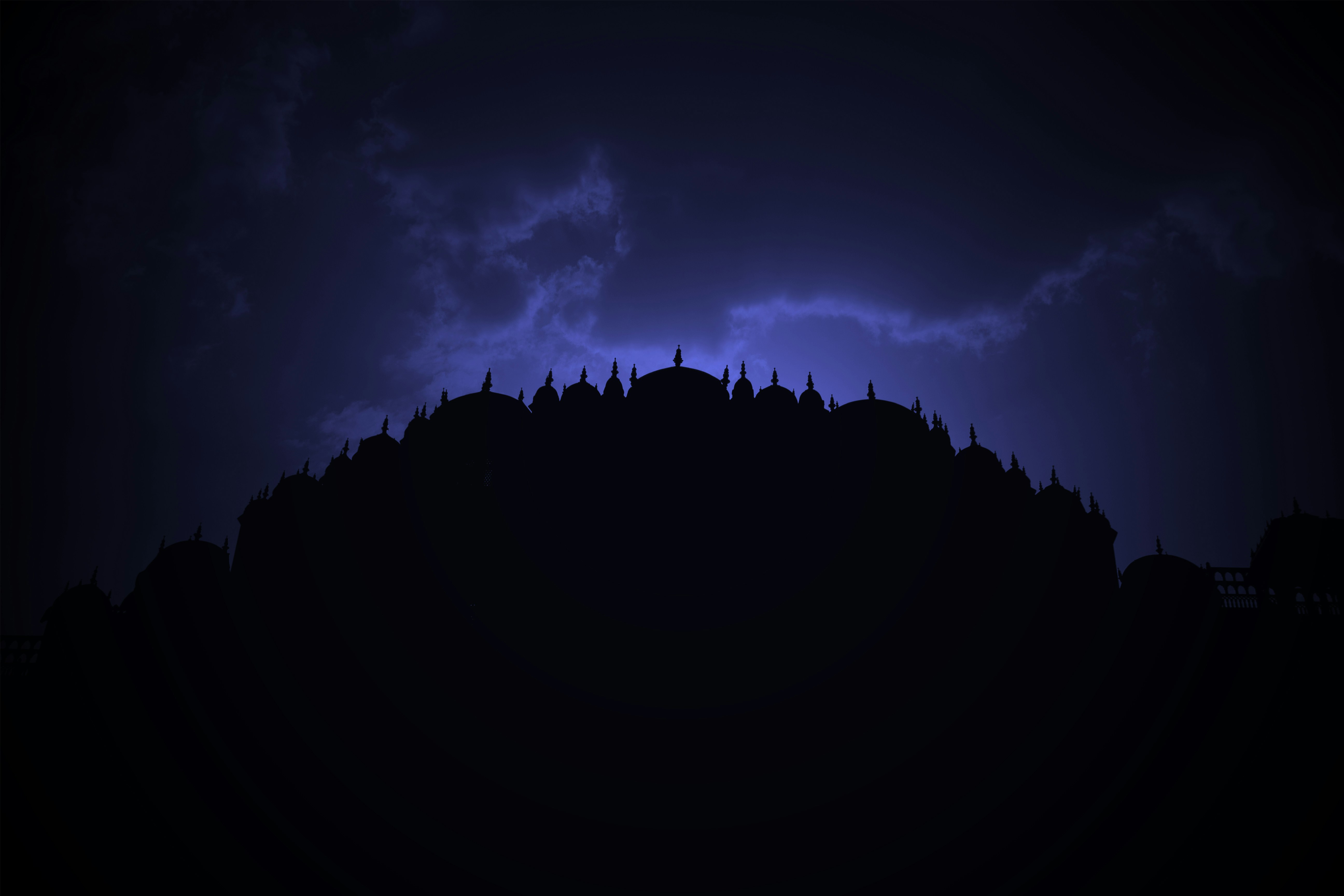 the silhouette of a building against a dark sky