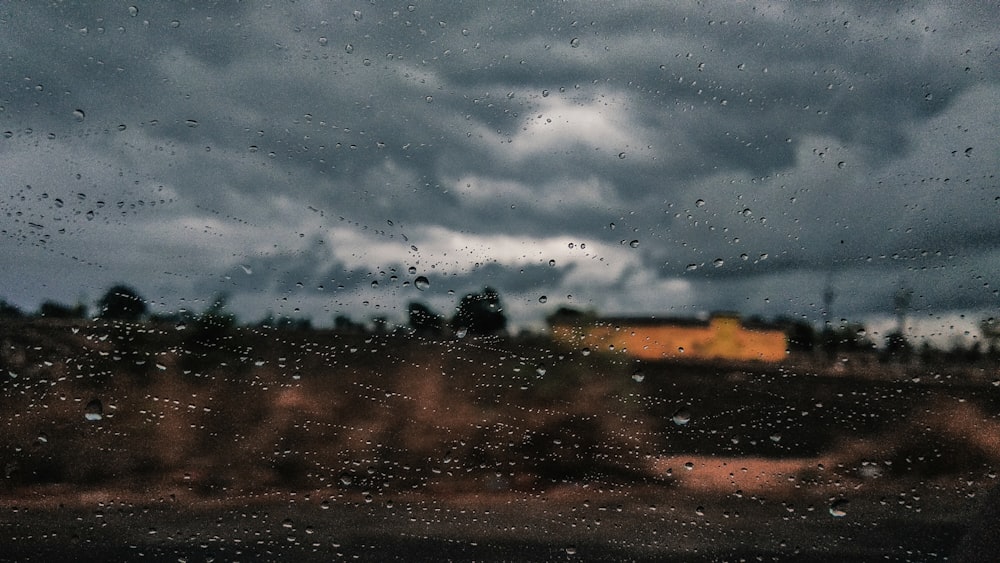 rain drops on a window with a house in the background