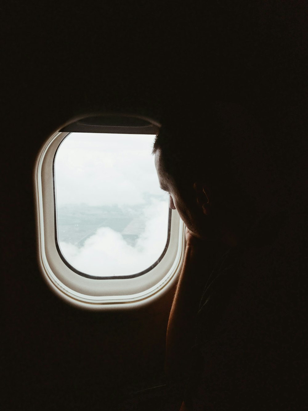 man looking in the outside the airplane window