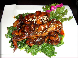 A beautifully plated Asian fusion dish featuring colorful vegetables and tender meat garnished with fresh herbs.