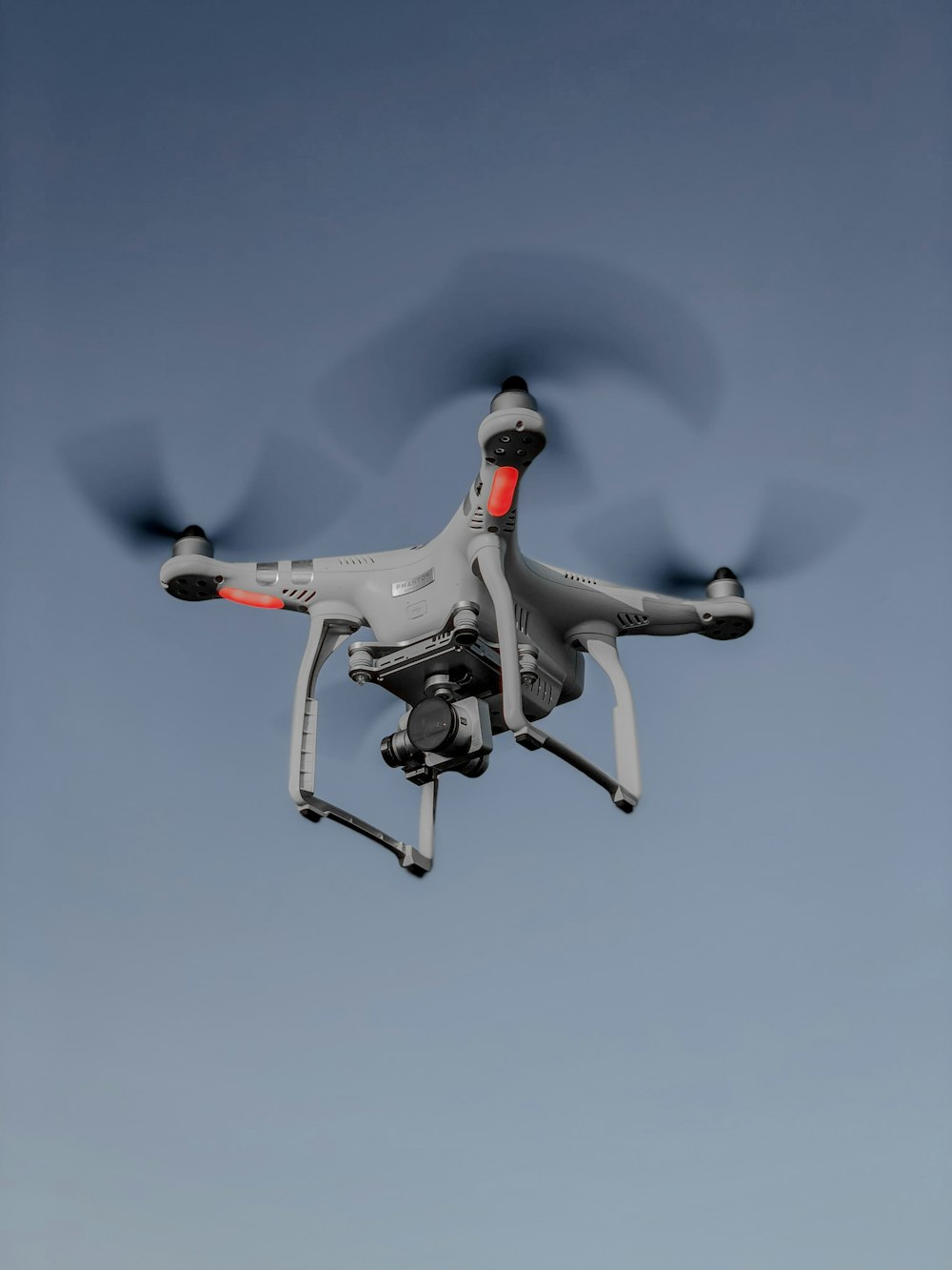 photo of flying white and red quadcopter drone