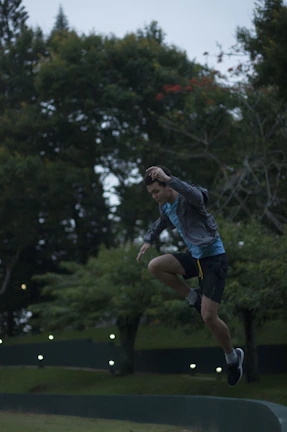 An athlete mid-jump outdoors, wearing Vitalux branded apparel, with a sunset backdrop.