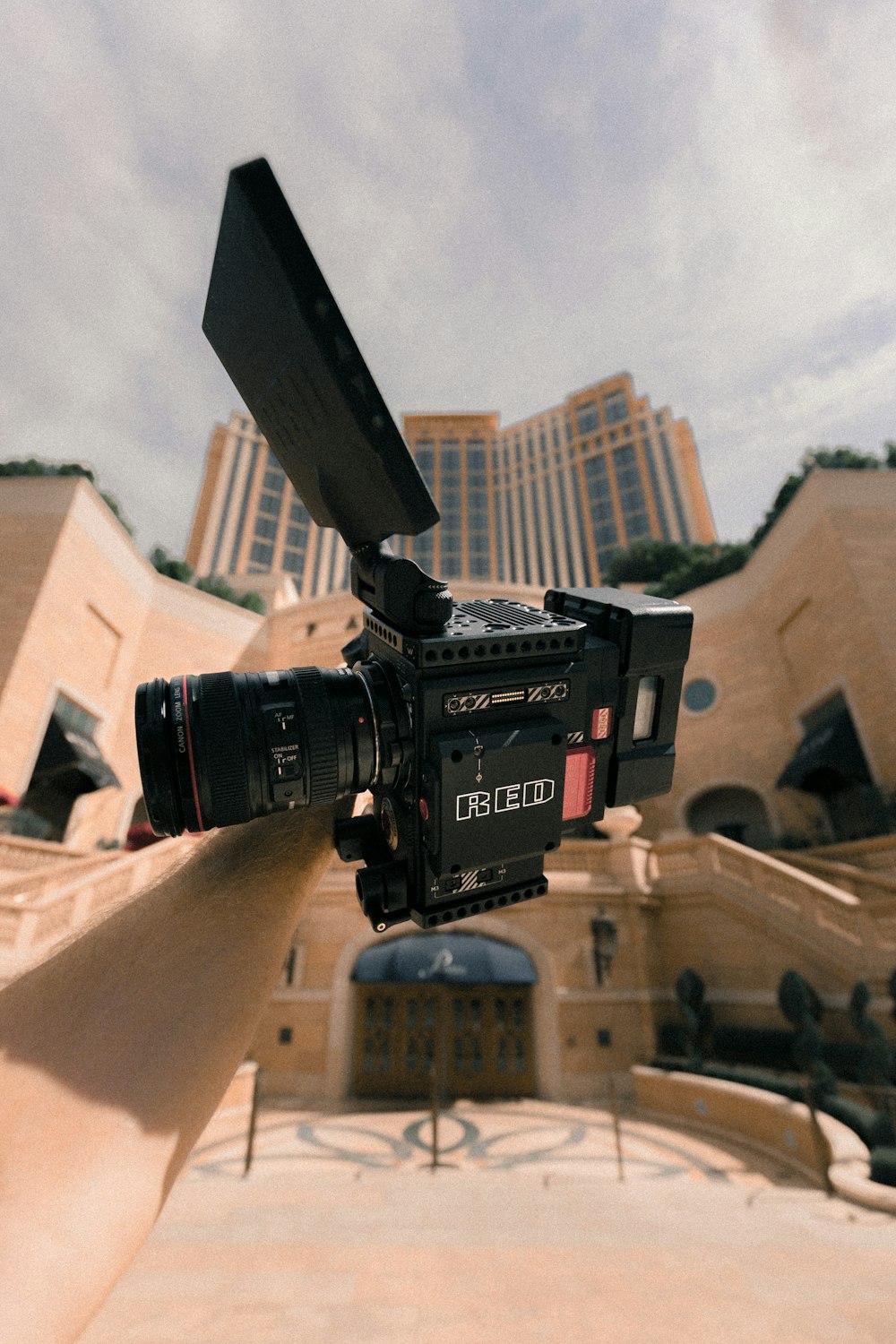 person holding black and grey camcorder under white sky at daytime