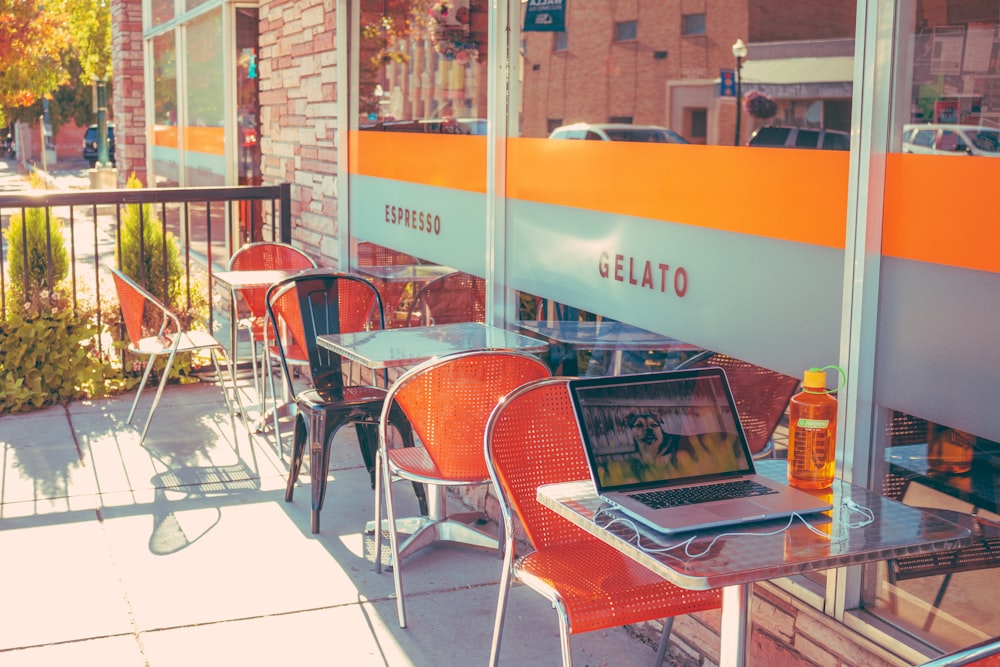 laptop on table beside orange bottle