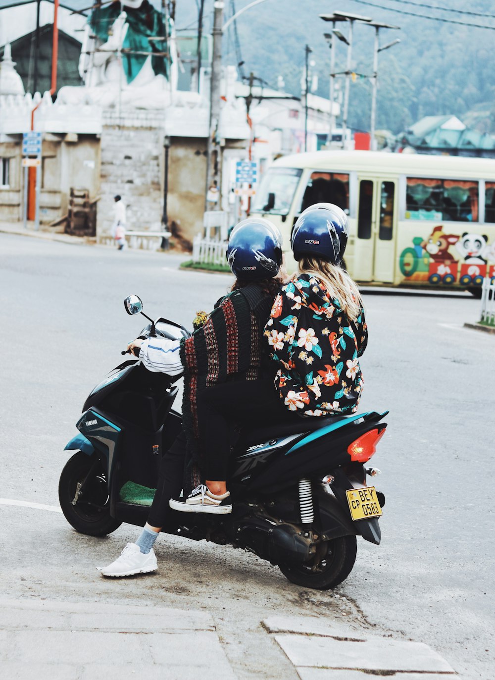 two person riding motor scooter