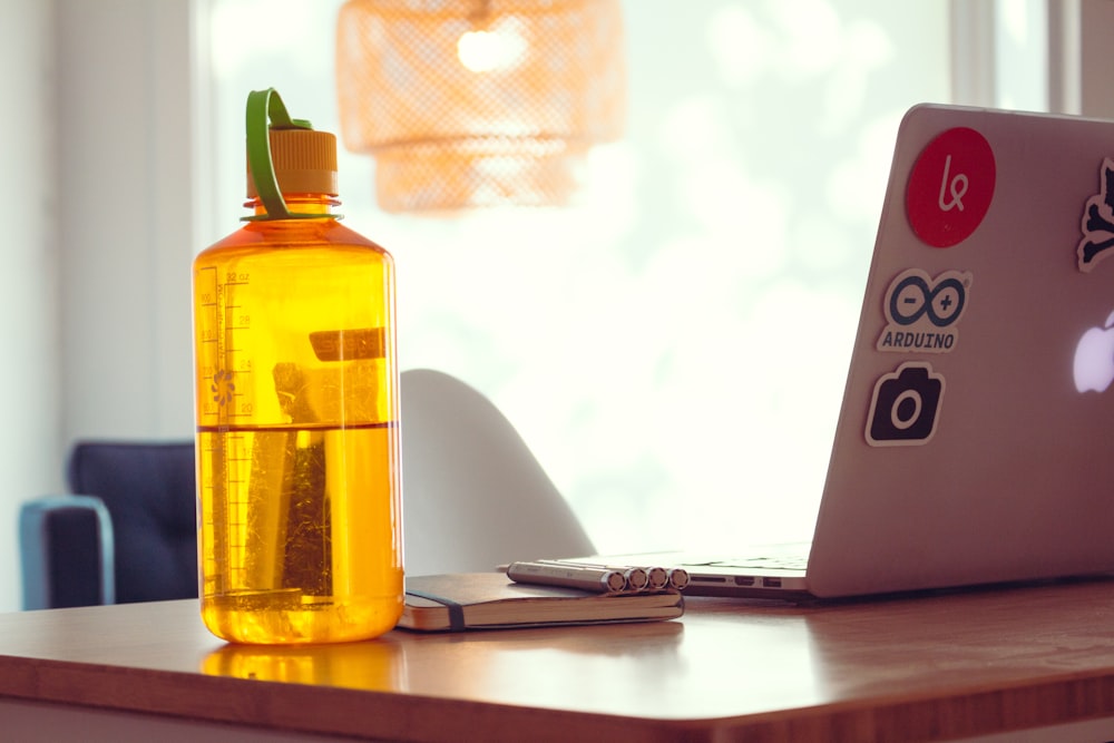 orange reusable bottle beside MacBook Air