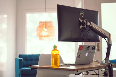 An adjustable desk mount supporting a computer screen with cable management