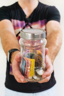 man holding clear glass jar